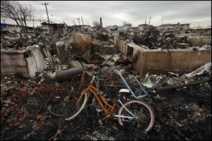 A burned bicycle lies in the ashes of a burned out home in the Breezy Point section of the Queens borough of New York. 