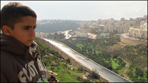 Emad's son Gibreel looks over the Israeli-built wall at Israeli settlements.  The scene is from the documentary to be shown at the St. Francis Convent Campus in Tiffin on Dec. 1.