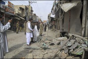 Pakistani security officials check the site of a bomb blast as the minority Muslim Shia sect observes the annual Ashoura holiday in Dera Ismail Khan, Pakistan, Sunday.