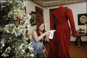 Curator Holly Hartlerode steams a period dress while setting up a Victorian-era parlor for the upcoming Old Home Holiday Tour at the Wood County Historical Center and Museum.