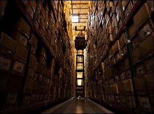 Daniel Holmquist raises his forklift to the top shelf of the Sierra Trading Post Fulfillment Center's racks to a pick a product off the shelves at the facility in Cheyenne, Wyo.