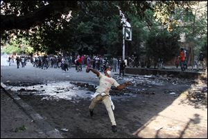 Egyptian protesters clash with security forces, not pictured, near Tahrir Square in Cairo, Egypt, Sunday, Nov. 25, 2012. President Mohammed Morsi edicts, which were announced on Thursday, place him above oversight of any kind, including that of the courts. The move has thrown Egypt's already troubled transition to democracy into further turmoil, sparking angry protests across the country to demand the decrees be immediately rescinded. (AP Photo/Ahmed Gomaa)