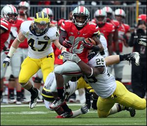 Ohio State wide receiver Corey Brown, center, attempts to elude Michigan linebackers Kenny Demmens, right, and Jake Ryan on Saturday in Columbus. Ohio State won 26-21.