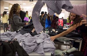 Shoppers rummage through a pile of sweaters on sale at a J.C. Penney store, in Las Vegas, on Black Friday.