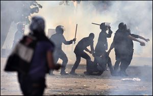 Egyptian security forces arrest a protester during clashes near Tahrir square in Cairo, Egypt, Tuesday, Nov. 27, 2012. Egyptian protesters and police clashed in Cairo on Tuesday just hours ahead of a planned massive rally by opponents of the country’s Islamist president demanding he rescinds decrees that granted him near-absolute powers.(AP Photo/ Khalil Hamra)