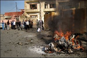 Iraqis inspect the scene of a bomb attack in Kirkuk, 180 miles north of Baghdad, Iraq.