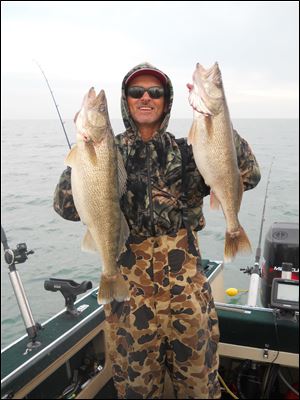 Bryan Johnson of Oregon with two large walleyes he caught during a late November fishing spree off Niagara reef in Lake Erie.