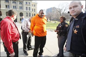 An unidentified man is one of a handful of people taken into custody by Lucas County Deputies after a disturbance in the on in front of the Lucas County Courthouse.