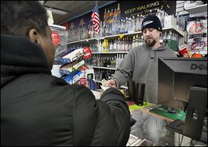 SLUG: CTY lottery                               Date: 11/28//2012 Toledo Blade/ Amy E. Voigt             Toledo, Ohio  CAPTION: Matt Opperman, right, Manager of  Ray's Party Store  on Main St., sells a Powerball tickets to Felicia Neal, left, from Toledo, on November 28, 2012. The size of tonight's jackpot has risen to about  $550 million by the afternoon.