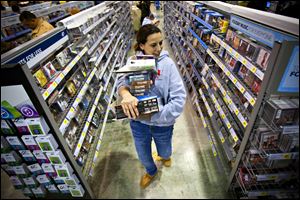 A shopper loaded down with purchases makes her way through the aisles at Best Buy in Bowling Green, Ky., at the start of the Thanksgiving shopping weekend. U.S. consumer confidence rose this month to its highest level in almost five years, the Commerce Department reported Tuesday.