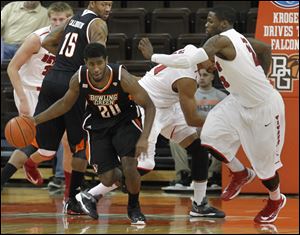The Falcons' Jehvon Clarke dribbles the ball past Doug Anderson, right, after pulling down a rebound.