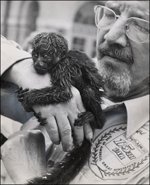 Mr. Klewer, a former zoo director, shows off a monkey after safari members returned to the Toledo Zoo.