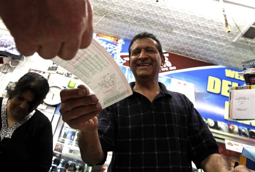 As-he-hands-over-a-customer-s-lottery-ticket