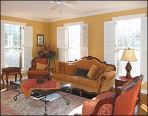 Classic white plantation shutters allow abundant sunlight into the formal parlor.