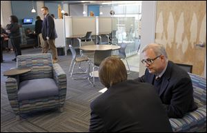 Theology teacher Mike Wielgopolski helps senior Alex Lincoln prepare for an exam at the new Student Achievement Center at St. Francis de Sales High School. The 6,000-square-foot center, dedicated on Thursday, has SMART boards, computers, flatscreen TVs, and few physical books.