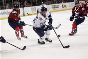 Luke Glendening, of the Toledo Walleye, tries to gain control of the puck during the first period of their game against the Kalamazoo Wings at the Huntington Center in Toledo.