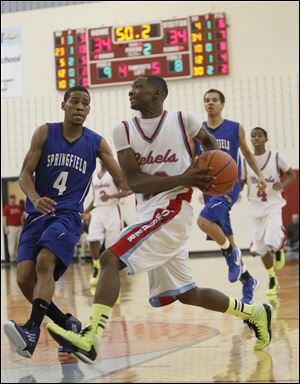 Bowsher High School player Dajuan King, 13, drives against Springfield High School player Marquan Hodges, 4, during the second quarter at Bowsher High School.