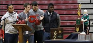 Central Catholic High School football team captains from left to right Ian Butler, Mitch Cochell, Jeff Dew, and Amir Edwards present the team's trophies to the school.