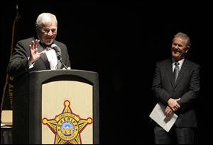 Lucas County Sheriff James Telb, at podium, with Sheriff-elect John Tharp, right, during a retirement party at the SeaGate Convention Centre in honor of Sheriff Telb, who is about to retire.