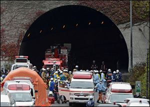 Police officers and firefighters gather at the exit of the Sasago Tunnel on the Chuo Expressway in Otsuki, Yamanashi Prefecture, central Japan today.