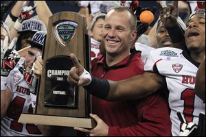 Northern Illinois coach Dave Doeren holds the Mid-American Conference championship trophy after his team defeated Kent State 44-37 in double overtime Friday in Detroit. Doeren has since left to accept the job at North Carolina State, but he did lead the Huskies to a BCS berth this season.