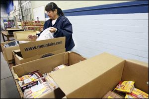 Staff member Delores Reyes packs bags of meat donated by Kroger at the Toledo Seagate Food Bank.