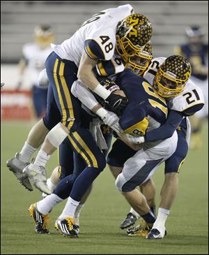 Whitmer’s Nate Holley is tackled by Cincinnati Moeller's Paul Barron, left, Sam Hubbard, and Chris Kessling in  the second quarter of the Division I state championship game in Canton.