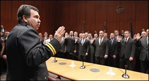 Toledo Fire and Rescue Department Battalion Chief Dave Dauer administers the oath of office to 43 new fire recruits a during a ceremony at One Government Center.