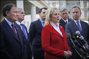 National Governors Association Vice Chair, Oklahoma Gov. Mary Fallin, center, talks to reporters outside the White House in Washington today following a meeting between the NGA executive committee and President Obama regarding the fiscal cliff. From left are, Utah Gov. Gary Herbert, Minnesota Gov. Mark Dayton, Wisconsin Gov. Scott Walker, Fallin, Arkansas Gov. Mike Beebe, and NGA Chairman, Delaware Gov. Jack Markell. 
