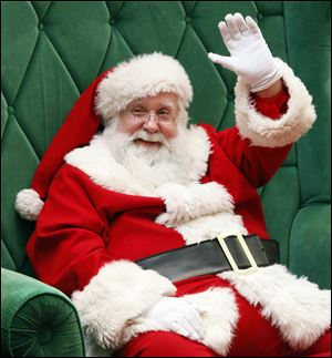 Santa Claus waves to people passing by in Westfield Franklin Park Mall.