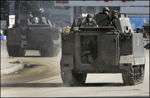 Lebanese army soldiers patrol in armored vehicles after clashes erupted between pro and anti-Syrian regime gunmen in the northern port city of Tripoli, Lebanon.