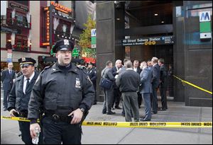 Uniformed and plainclothes police officers stand outside a New York subway station after a man was killed after falling into the path of a train.