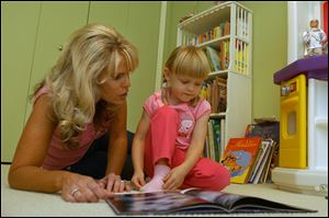 Sharon Saarinen and Alana Saarinen read together in Alana’s bedroom in their West Bloomfi eld, Mich., home.