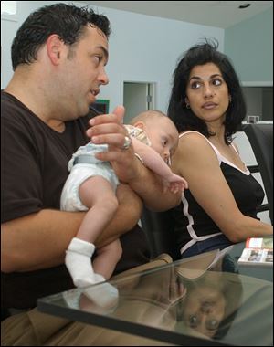 Antonio Borrello holds his daughter, Gianna Borrello, while his wife, Theresa Pavone, listens to him talk about the in vitro fertilization procedure that was used to create Gianna.
