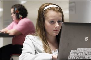 Brooklyn Grant, right, 14, of Toledo, tackles coursework on a cmoputer at Nexus Academy, a public charter school in downtown Toledo.