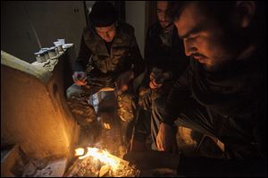 Syrian rebels make a fire to keep warm after clashes with troops loyal to Syrian President Bashar Assad at on the front line in Aleppo, Syria. 