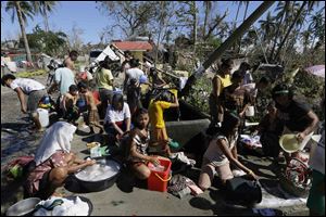 Typhoon evacuees wash their clothes and take a bath at an evacuation center at Maparat township, Compostela Valley in southern Philippines on Saturday.