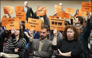 Catey Pioli, a Bowling Green State University graduate student, left, Scott Magelssen, an associate professor of theater, and Diana DePasquale, a graduate student and teaching assistant,  join a large group of faculty members at a trustee meeting to protest the lack of a labor contract with the school.