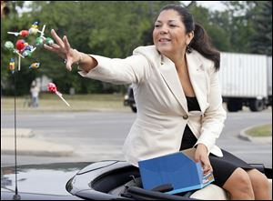 Lucas County Auditor Anita Lopez throws candy during a parade in July. “I have not officially announced that I will be running for mayor. But I am seriously considering running,” Ms. Lopez said last month.