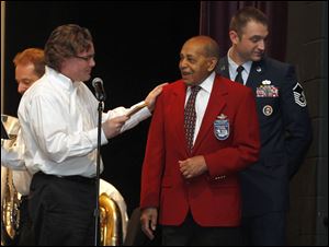 From left: Announcer Jeremy Meier, Col. USAF (Ret.) Harold H. Brown, and 180th FW Color Guard member Master Sergeant Brad Haas during a tribute to Brown on Sunday at the Holiday and Tribute Concert at the Fine & Performing Arts Center in Perrysburg.