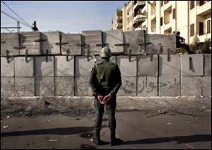 An Egyptian soldier stands guard in front of the presidential palace in Cairo, Egypt.