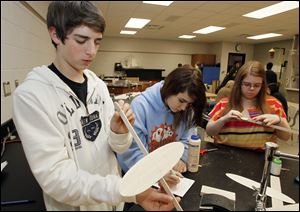 Freshmen Michael Donofrio, left, and Emily Stephens, center, along with junior Ellen Tolson make a balsa wood airplane during practice for the Science Olympiad Invitational at Northview High School.