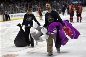 Tony Bibler, a marketing promotion intern for the Toledo Walleye, helps carry out large stuffed animals that were thrown onto the ice during the annual Teddy Bear Toss at Huntington Center. The event, which was Dec. 1 this year, yielded a zoo’s worth of stuffed animals.
