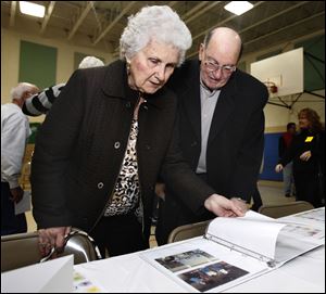 Peggy Rabideau, who used to work at the school, and Dominic Bruno, whose late wife taught there, look at photos as others mingle and reminisce at Central Elementary.