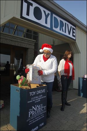 Volunteers Barbara Brotzki, left, and Lisa Harris collect toys for the Noel Project at the Church on Strayer. The Noel Project accepts donations of new, $10 toys.