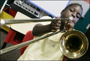 A student tests his trombone at the Toledo School for the Arts. The school, which enrolls about 580 students, typically has a waiting list of about 100, school director Martin Porter said. Under the expansion, the school plans to accept up to 60 more students in grades nine through 12.