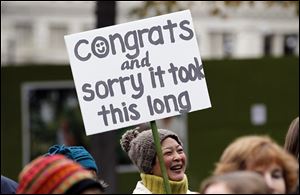 Cindy Ogasawara and others greet newly married couples as they leave Seattle City Hall. Weddings took place all across the state on Sunday.