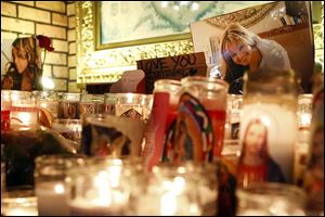 Candles and pictures are displayed to pay tribute to singer Jenni Rivera at the Plaza Mexico shopping center in Lynwood, Calif., early today.