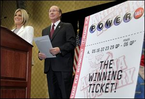 Arizona Lottery Director of Budget, Products and Communications Karen Bach, left, and Arizona Lottery Executive Director Jeff Hatch-Miller stand next to an enlargement of the winning $587.5 Million Powerball ticket.