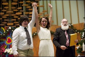 Jessica Lee, 19, left, and Ashley Cavner, 21, from Vancouver, Wash., complete their wedding vows shortly after midnight Sunday morning as the Rev. Rob Figley looks on. Washington, Maine, and Maryland became the first states to pass same-sex marriages by popular vote.